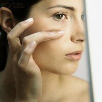 Woman Examining Face in Mirror